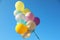 Many sunlit bright balloons in blue sky
