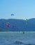 Many surfers enjoying kite surfing at the beach
