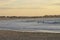 Many surfers sit and lie on their surfboards between breaking approaching waves on a beach in Portugal