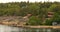 Many Swedish Wooden Sauna Logs Cabins Houses On Island Coast In Summer Cloudy Day