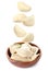 Many tasty dumplings falling into wooden bowl on background