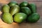 Many tasty ripe avocados on wooden table