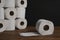 Many toilet paper rolls piled in a heap. Soft hygienic paper. Wooden table on black background
