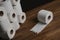 Many toilet paper rolls piled in a heap. Soft hygienic paper. Wooden table on black background