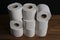 Many toilet paper rolls piled in a heap. Soft hygienic paper. Wooden table on black background