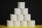 Many toilet paper rolls. Soft hygienic paper. Black yellow background