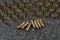 many Tokarev pistol cartridges on a gray granite background - six cartridges are lying in the middle and the rest is standing