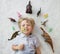 Many toy dinosaur figures around head of cute toddler boy