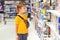 Many toys around. Kids shop. Sales, discounts and shopping. Cute boy selecting toys in store