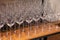 Many transparent crystal wine glasses stand in row on the brown wooden shelves of the rack. Side view. The concept of tasting