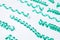 Many turquoise serpentine streamers on white background