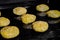 Many uncooked homemade oatmeal cookies on metal sheet in oven