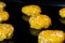 Many uncooked homemade oatmeal cookies on metal sheet in oven, black background