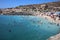 Many unidentified People on the Beach of Hondoq Bay. Island of Gozo. Malta