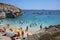Many unidentified People on the Beach of Hondoq Bay. Island of Gozo. Malta