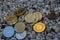 many valueable golden shining and silver coins bitcoin ether and ada from cryptocurrency lying on a white gravel