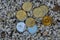 many valueable golden and silver coins bitcoin ether and ada from cryptocurrency lying on a white gravel view from above