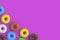 Many various donuts on violet background