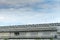 Many ventilation chimneys on the factory roof at blue sky and clouds