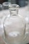 Many vintage clear glass bottles are close together, light