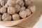 Many walnuts in a bowl. Bowl on burlap. White wooden background. Close-up
