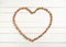 Many Walnuts in Heart Shape in flat lay on distressed White Board Background with empty room or space for copy, text, your words