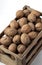 Many walnuts in a mini wooden crate on a white background on top view Still life photography