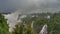 Many waterfalls collapse from ledges of rocks into the bed of a stormy river.