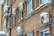 Many white air conditioning part of a split system hanging on a brick wall of a building covered in snow and icicles in winter in