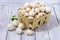 Many white champignons in a white wooden basket. Basil leafs. Cold mod.