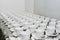 Many white clean empty cups and saucers stand in rows on the table