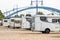 Many white modern campervan recreational motor home vehicles parked in row at camper park site Magdeburg city against