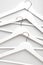 Many wooden white hangers on white wall background