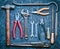 Many working tools on a black concrete table. Nippers, file, pliers, scrap, hammer, wrench, screwdriver. Top view. Flat lay.