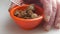 Manâ€™s fingers around a bowl eating smoked scallops