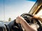 Manâ€™s hands holding steering wheel and road background. Drivin