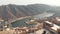 Maota Lake overlooked by Amber Fort embellished with Kesar Kyari Garden in Jaipur, Rajasthan, India - Aerial Fly-over shot