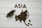 Map of the Asia made of roasted coffee beanMap of the Asia made of roasted coffee bes laying on white wooden textured background