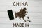 Map of the China made of roasted coffee beans laying on white wooden textured background with phone