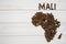 Map of the Mali made of roasted coffee beans laying on white wooden textured background