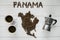 Map of the Panama made of roasted coffee beans laying on white wooden textured background with cups of coffee and coffee maker