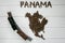 Map of the Panama made of roasted coffee beans laying on white wooden textured background with toy train