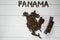 Map of the Panama made of roasted coffee beans laying on white wooden textured background with toy train