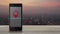 Map pin point location button on modern smart mobile phone screen on wooden table over blur of cityscape on warm light sundown, Ma