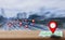 Map pointer icon placed on a wooden table, the background is blurred city streets and traffic jam,With the concept of using