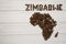 Map of the Zimbabwe made of roasted coffee beans laying on white wooden textured background