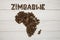 Map of the Zimbabwe made of roasted coffee beans laying on white wooden textured background