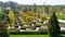 Maple alley in French garden in public landscape city park `Krasnodar` or `Galitsky park`. Wooden circular brown benches