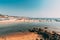 Mapusa, Anjuna, Goa, India. People Visit And Relax On Baga Beach At Sunny Evening Under Blue Sky.