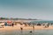 Mapusa, Anjuna, Goa, India. People Visit And Relax On Baga Beach At Sunny Evening Under Blue Sky.